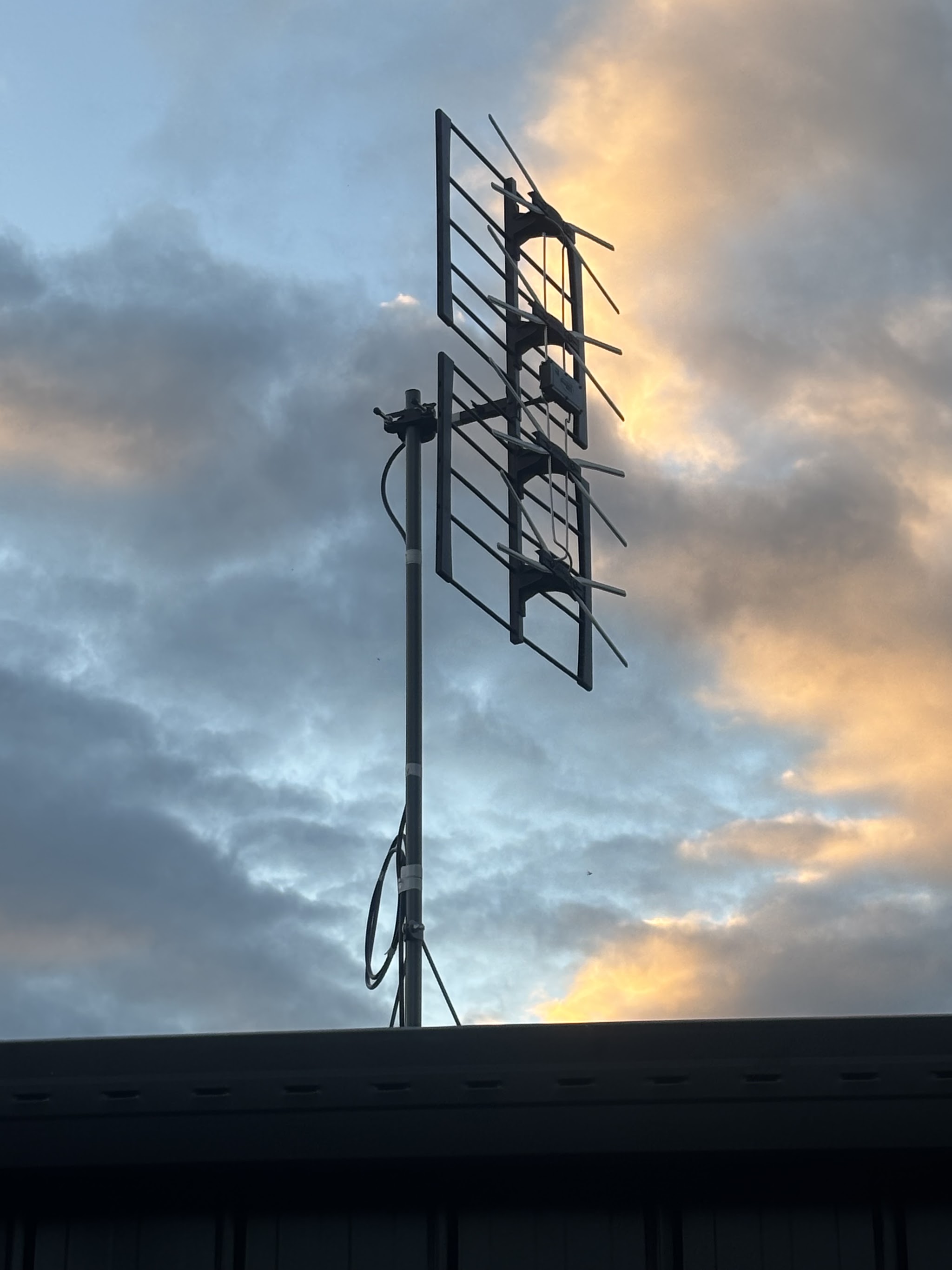 Television antenna installed on a roof against an evening sky