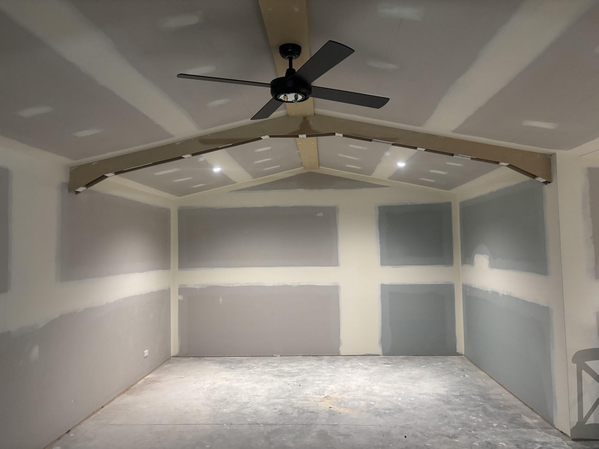 Alfresco area with a black ceiling fan and downlights in a raked ceiling