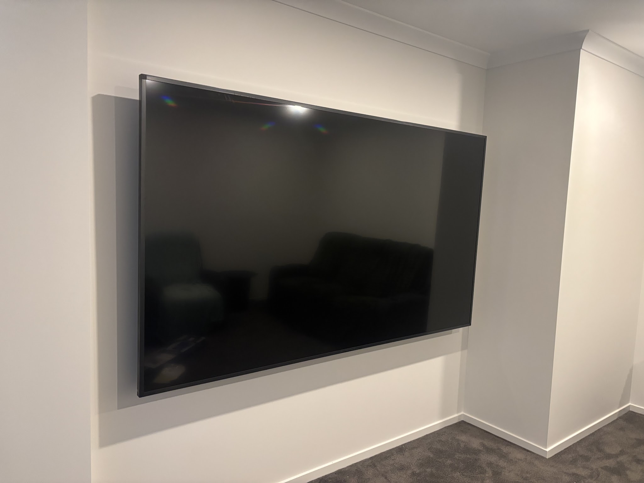 Large flat screen television wall mounted in a living room with the cabling concealed