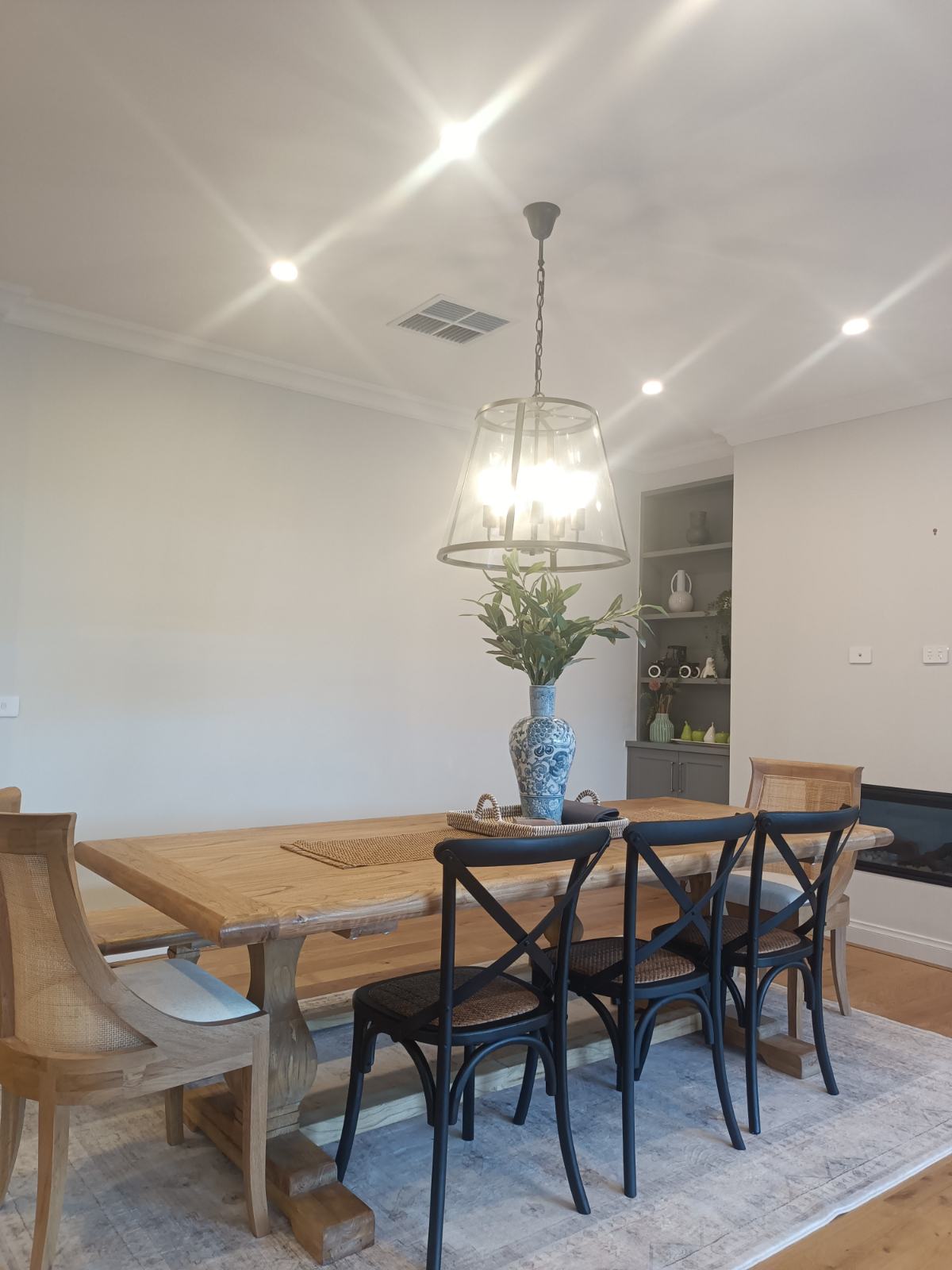 Dining room with a pendant light over the table and recessed downlights