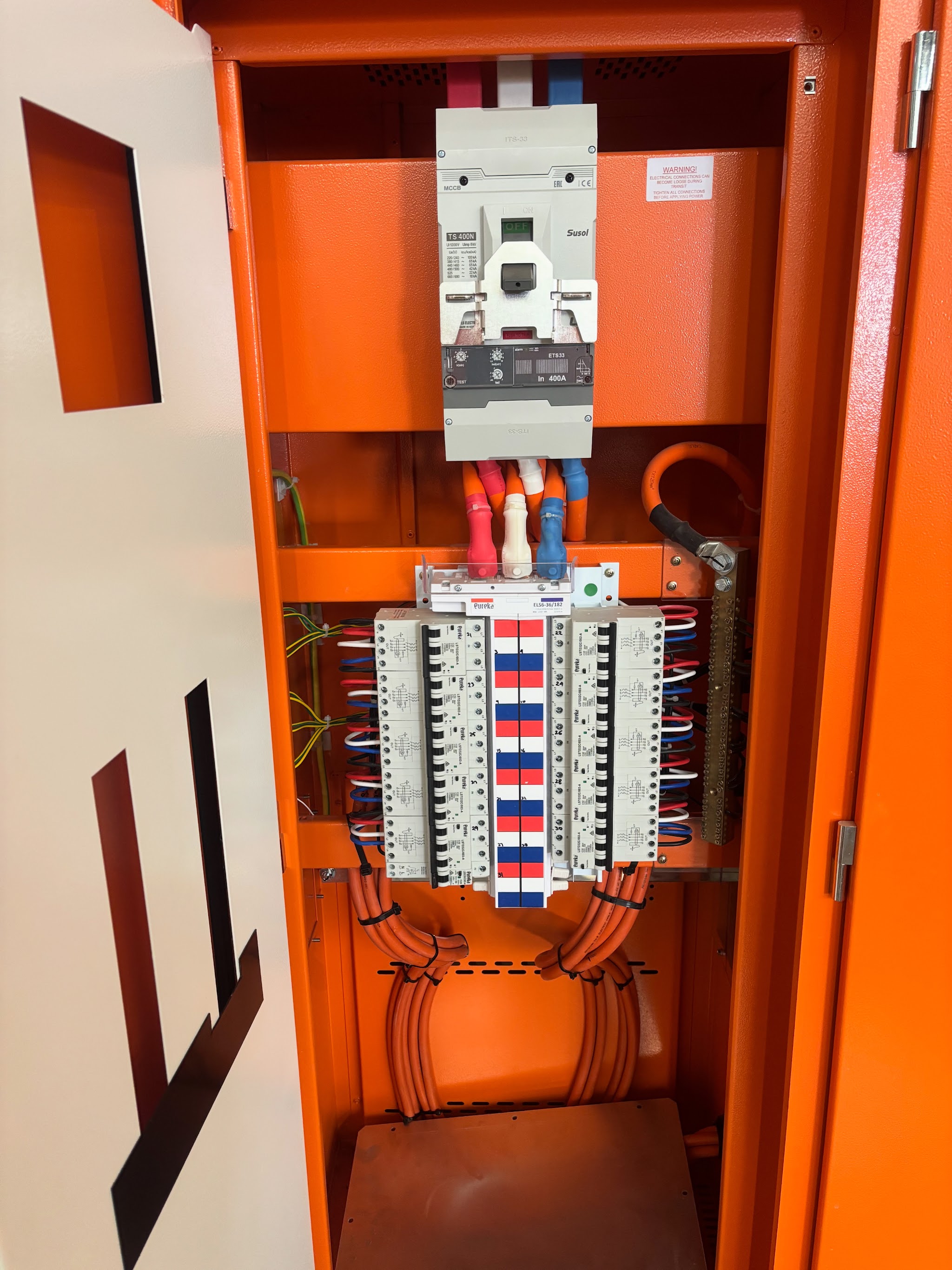 Switchboard cabinet open showing a neatly wired bank of circuit breakers